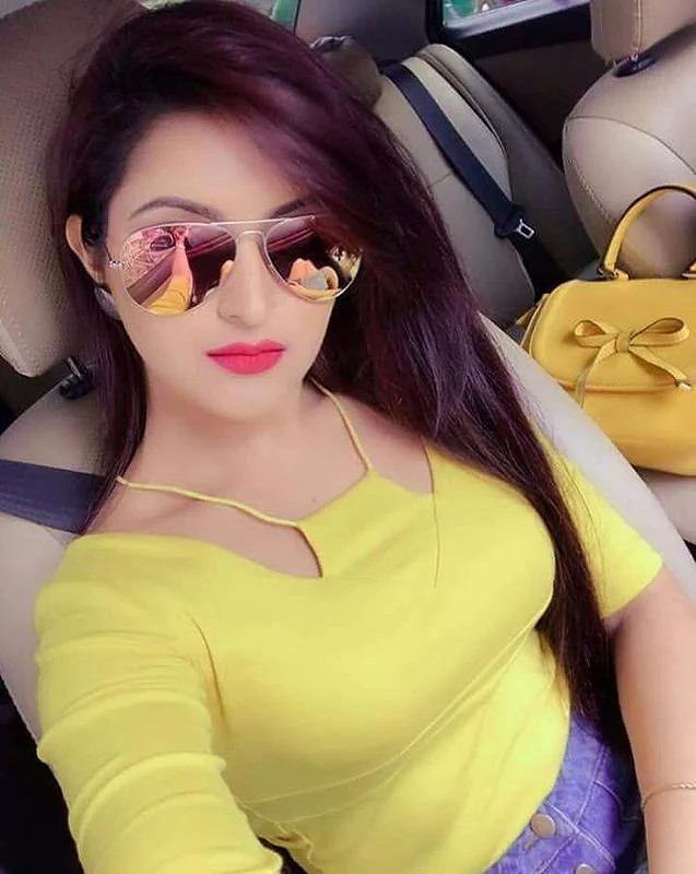 A GIRL IN YELLOW DRESS WEARING GOOGLESS SITING IN TH ECAR TAKING SELFIE